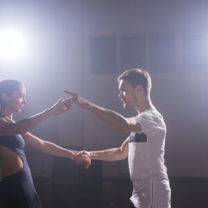 Young couple dancing social danse kizomba or bachata or semba or taraxia in dancing class background