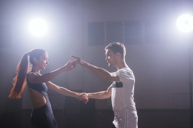 Young couple dancing social danse kizomba or bachata or semba or taraxia in dancing class background